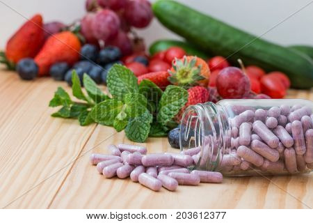 Vitamins supplements in the buttle and wooden table.