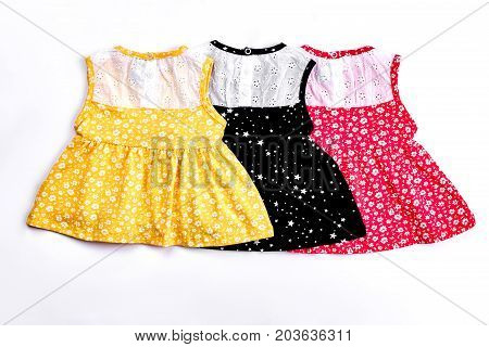 Infant girl cute design sundresses. Collection of beautiful patterned drsses with embroidery for baby-girls, white background. Infant girls casual summer outfit.