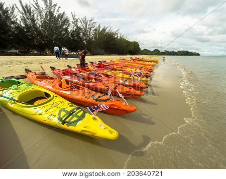 Labuan,Malaysia-Sept 9,2017:Colorful sea kayaks on sand beach with Malaysia flag in Labuan island,Malaysia.Malaysia is the ideal place for water sports,like white water rafting,kayaking,scuba diving & sailing.