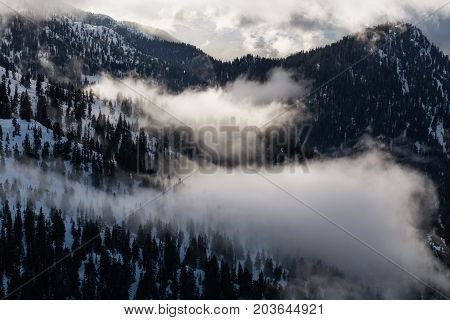 Aerial landscape view of the snow and cloud covered mountain range North of Vancouver British Columbia Canada.