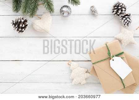Christmas composition. Christmas present gifts box pine cones fir leaves and decorations rustic elements on white wooden background. Creative flat lay top view design