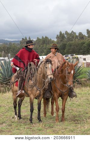 June 10 2017 Toacazo Ecuador: andean cowboys on horseback in traditional ponchos at a rural rodeo