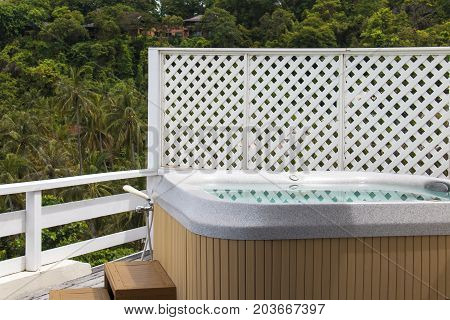 Wooden bathtub at outdoor. View nature from the terrace.