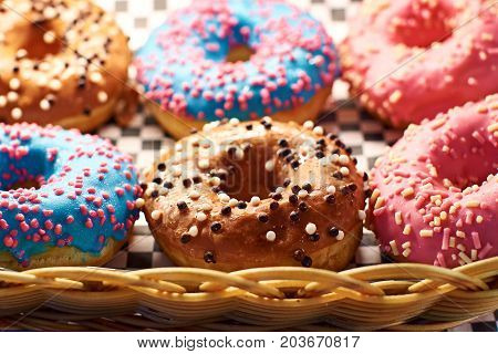 Colorful donuts in different colors in a whicker basket