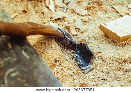 Rusty tip of sharp ax lies on edging boards