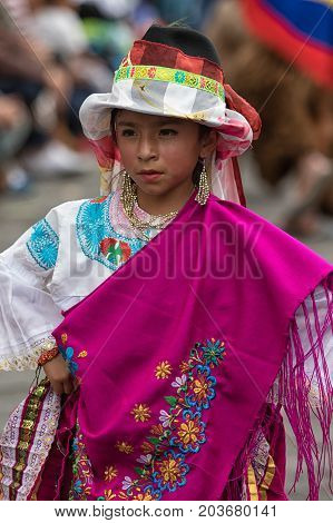 June 17 2017 Pujili Ecuador: young indigenous girl in bright color traditional clothing at Corpus Christi parade dancing in the street