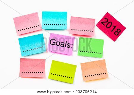 colorful sticky note paper with Goals 2018 on white wall background.