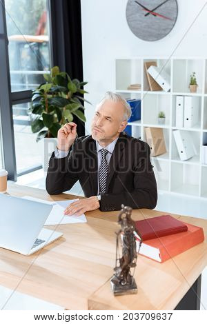 Mature Lawyer Sitting At Workplace