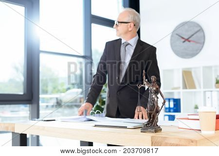 thoughtful mature lawyer working at modern office