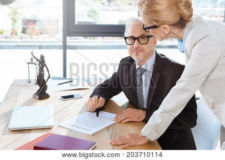 mature lawyers working with contract together in office