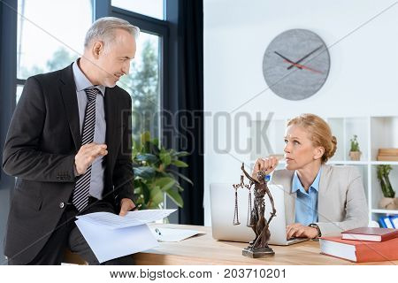 mature business colleagues discussing documents in office