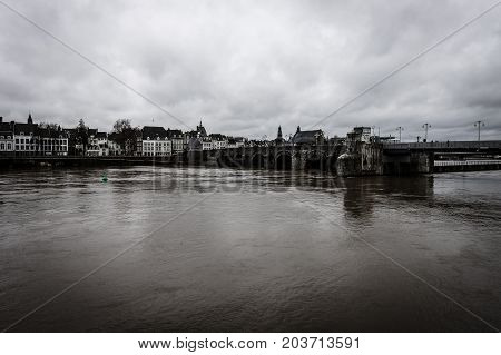 MAASTRICHT NETHERLANDS - JANUARY 09 2015: View of Maastricht city centre with its partly medieval bridge on the Meuse river. Sepia. Toning. Maastricht is the oldest city of the Netherlands and the capital city of the province of Limburg.