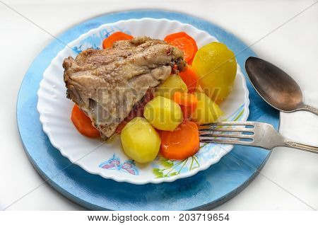 a hearty breakfast of chicken stewed carrot potatoes on a plate cupronickel cutlery