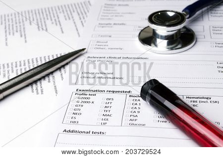pen stethoscope blood sample test tube and patient information form on desk heart healthcare technology medical diagnosis blood test medical report record and history patient concept