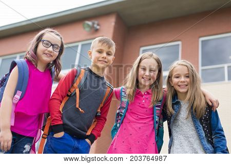 The Great Portrait Of School Pupil Outside Classroom Carrying Bags