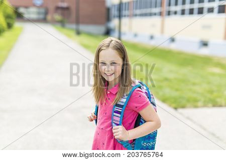 The Great Portrait Of School Pupil Outside Classroom Carrying Bags