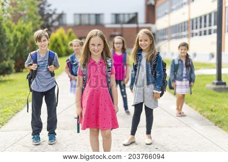 The Great Portrait Of School Pupil Outside Classroom Carrying Bags