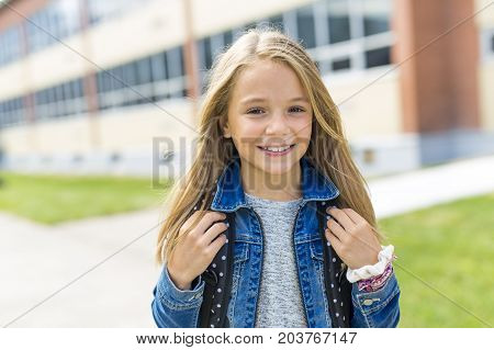 The Great Portrait Of School Pupil Outside Classroom Carrying Bags