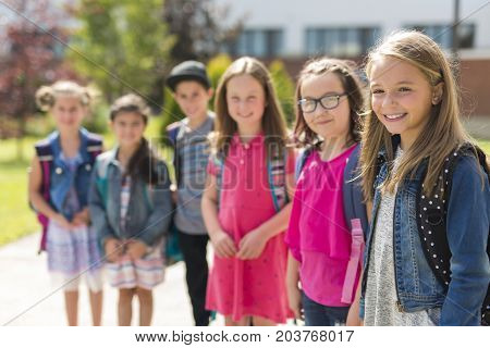 The Great Portrait Of School Pupil Outside Classroom Carrying Bags