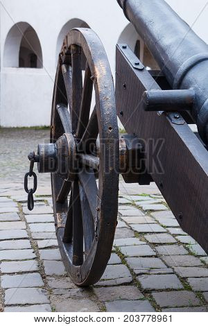 Wheel of ancient cannon with chain close up. Black colored cannon.