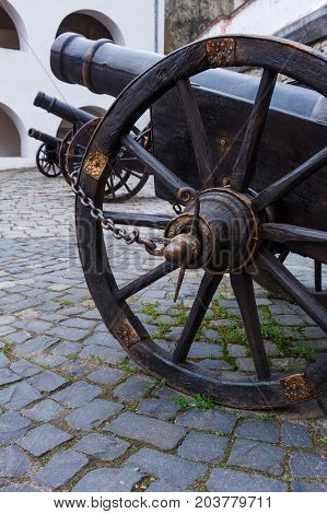 Ancient cannon on wheels close up and two cannons background. Bottom view