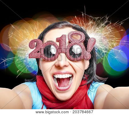 Two Thousand Eighteenth. New Years concept. Girl in glasses taking selfie.