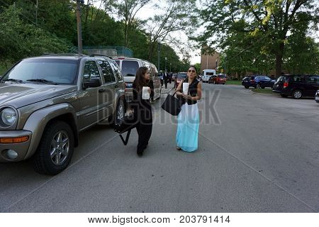 JOLIET, ILLINOIS / UNITED STATES - JUNE 1, 2017: People eat fresh popcorn while leaving an outdoor Concert on the Hill in the Billie Limacher Bicentennial Park.