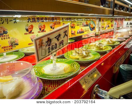 TOKYO, JAPAN -28 JUN 2017: Close up of assorted japanesse food over a table, inside of a kaitenzushi conveyor belt sushi restaurant in Tokyo, Japan.