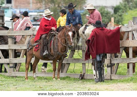 June 3 2017 Machachi Ecuador: cowboys from the Andes sitting on the fence in the morning in the high altitude town