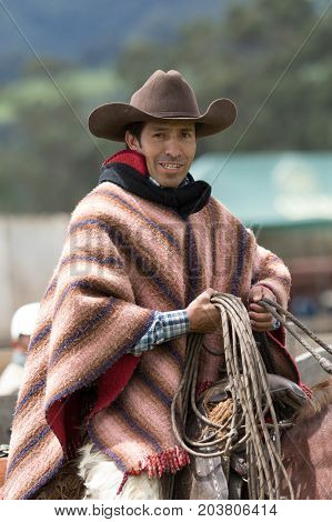 June 3 2017 Machachi Ecuador: cowboy in traditional poncho and chaps on horseback