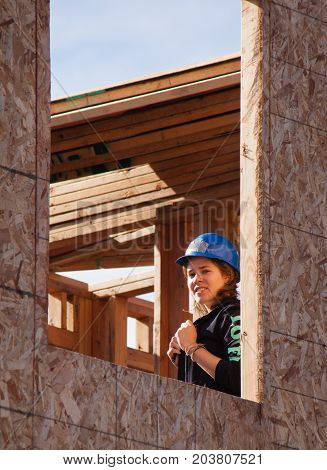 Oakland Calif - Jan 22 2011: Woman looks out unfinished window of home for Habitat For Humanity. El Rincon