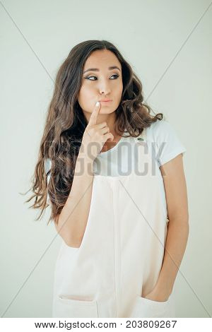 Studio Portrait Of Beautiful Young Woman Thinking And Looking Upwards