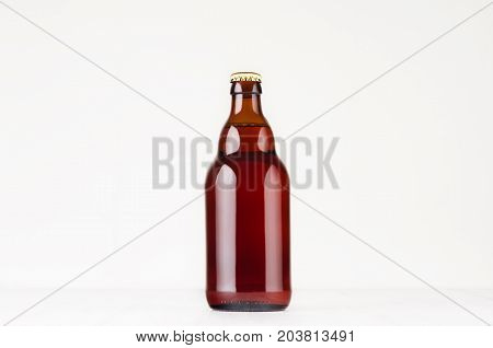 Brown steinie belgian beer bottle 330ml mock up. Template for advertising design branding identity on white wood table.