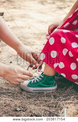 Friendly Family. Loving Mother Helping Her Little Daughter To Tie Shoelaces.