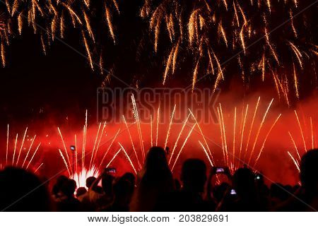 Abstract blurred unrecognizable crowd of young people at concert, show of Fireworks fun of youth, joint leisure, selective focus. Pyrotechnic devices for aesthetic and entertainment purposes, art