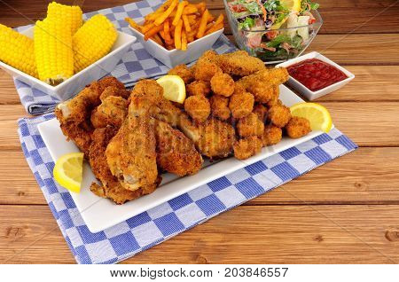 Collection of Southern fried chicken products with sweetcorn and salad
