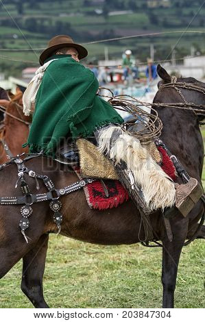 June 3 2017 Machachi Ecuador: closeup of Andean cowboy on horseback dressed traditionally on horseback working in field