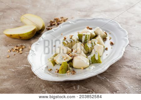 Delicious salad with pear, blue cheese sauce and almonds