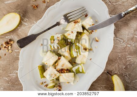Delicious salad with pear, blue cheese sauce and almonds