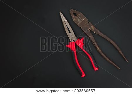 Must have at home used hand tools Combination Pliers and Needle Nose Pliers on black background with copy space
