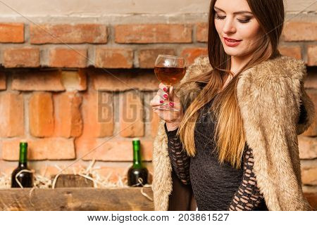 Woman Tasting Wine In Rural Cottage Interior