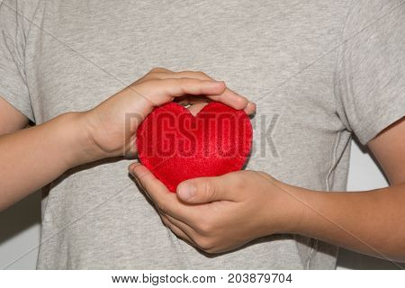 Young men hold red heart in hand.