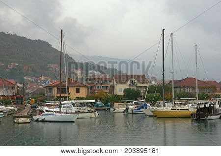 Fishing boats in harbor. Marina Kalimanj in the town of Tivat on a foggy autumn day. Adriatic Sea, Montenegro