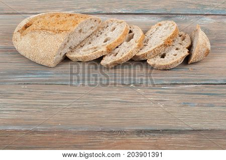 Many mixed breads and rolls of baked bread on wooden table background