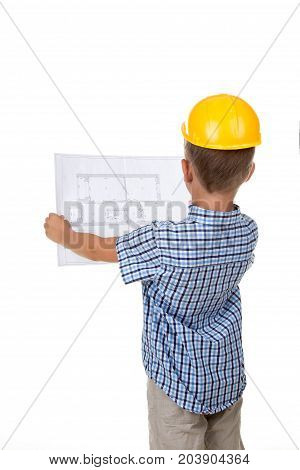 Young serious builder reading a construction plan, turned back, isolated on white background