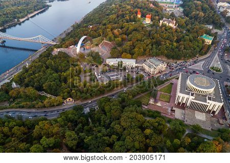 Panoramic view of a modern city at sunset. Skyline bird eye aerial view of the old part of the city under dramatic cloud sunset sky. General view of the right bank of Kiev with Arch of Friendship of Peoples, Khreshchaty Park, the main street of the city -