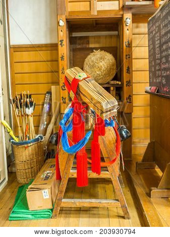 KYOTO, JAPAN - JULY 05, 2017: Close up of wooden structure with read and blue clothes inside of a temple in the city of Kyoto, Japan.