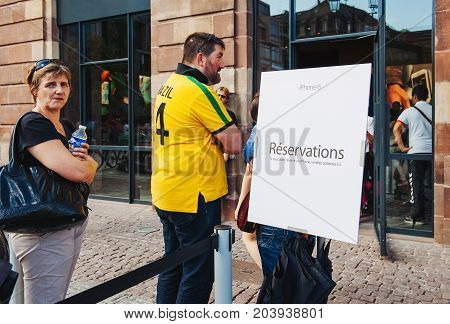 STRASBOURG FRANCE - SEP 20 2014: Customers waiting in line to pick-up their new reserved iPhone 7 from the Apple Store computer store selling iPad Apple Watch and iMac MacBook pro computers