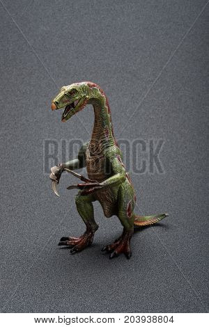 a nothronychus toy on a dark background