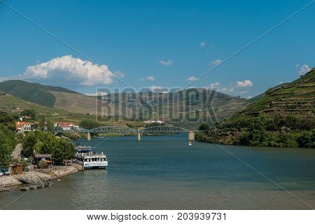 PESO DA REGUA PORTUGAL - JULY 8 2017: Bridge and quay over the river Douro valley Peso da Regua Portugal